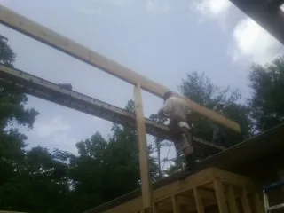 Carpenter setting a ridge beam over a new addition frame — Ice Dam Removal by Roofing Brothers in Bantam