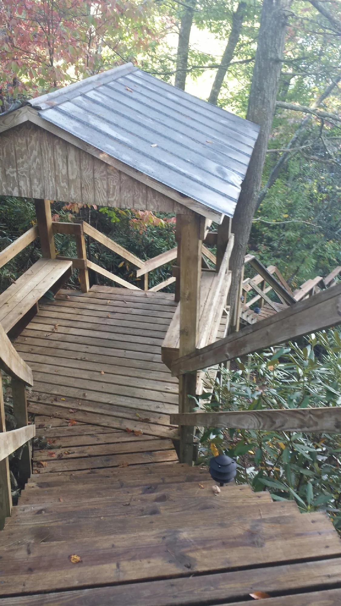 Metal roofed shelter over wooden steps on a wooded walkway — Skylight Repair & Installation work by our crew in Bantam